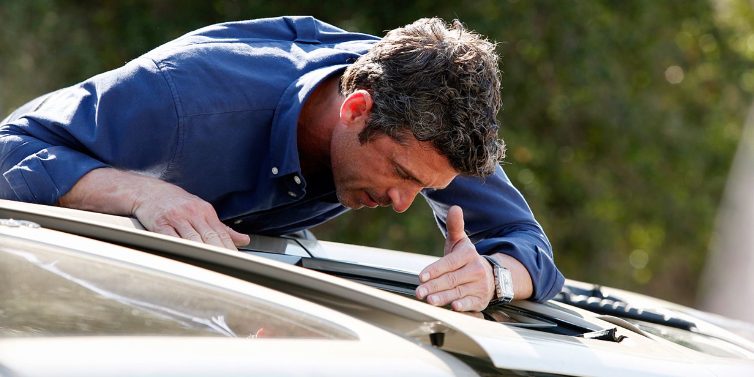 An image of Derek looking through a window of a car in Grey's Anatomy