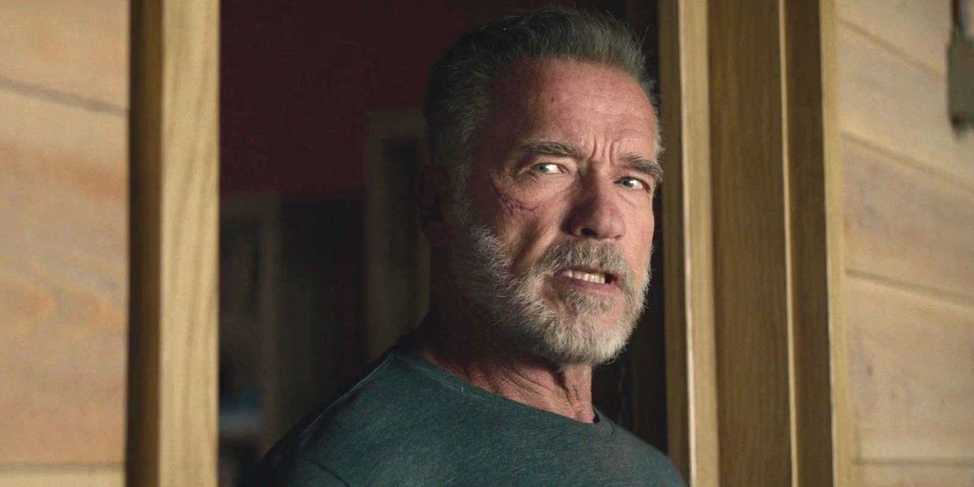 Arnold Schwarzenegger em Terminator Dark Fate com uma barba desalinhada em uma varanda conversando