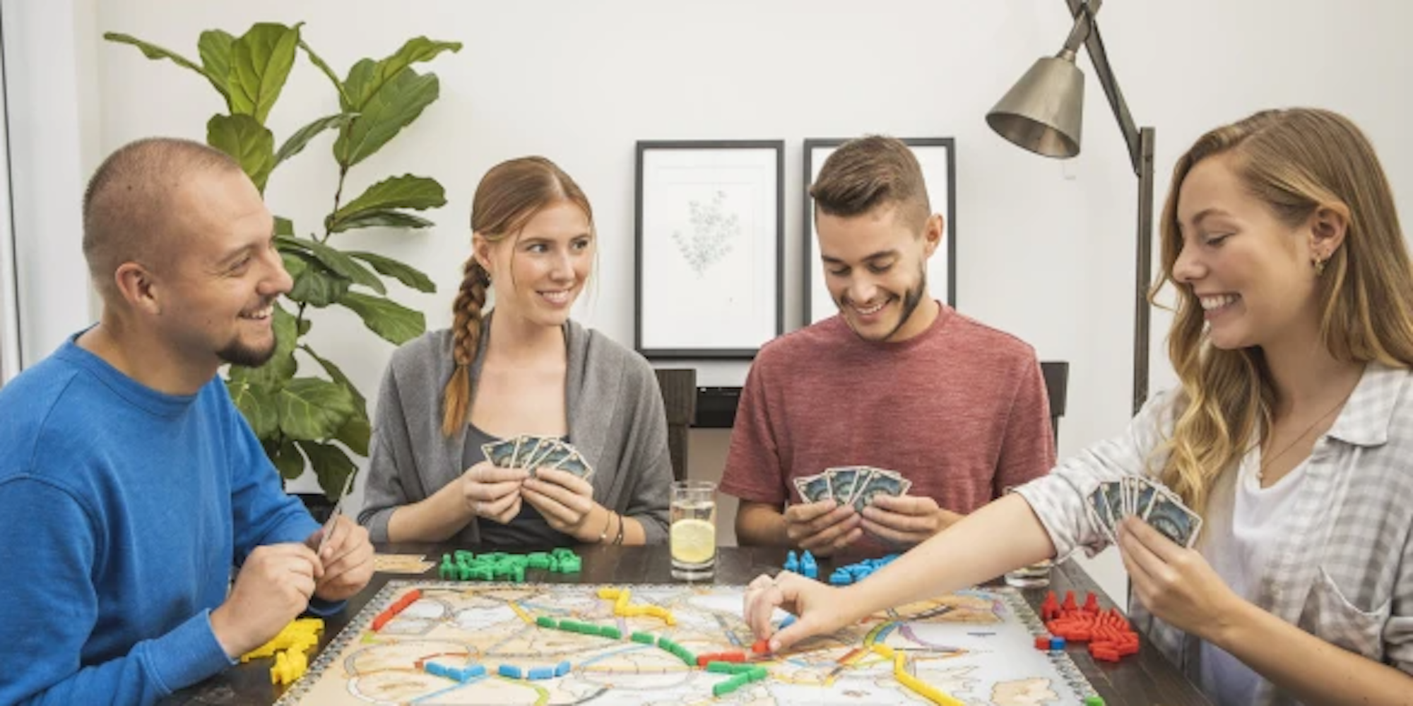 Four people are sitting and playing a card game.