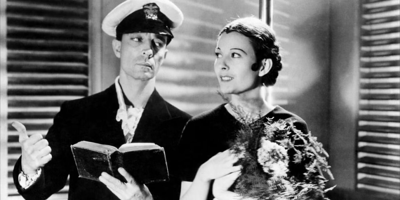 Buster Keaton holding a book and looking at a woman in Spite Marriage 