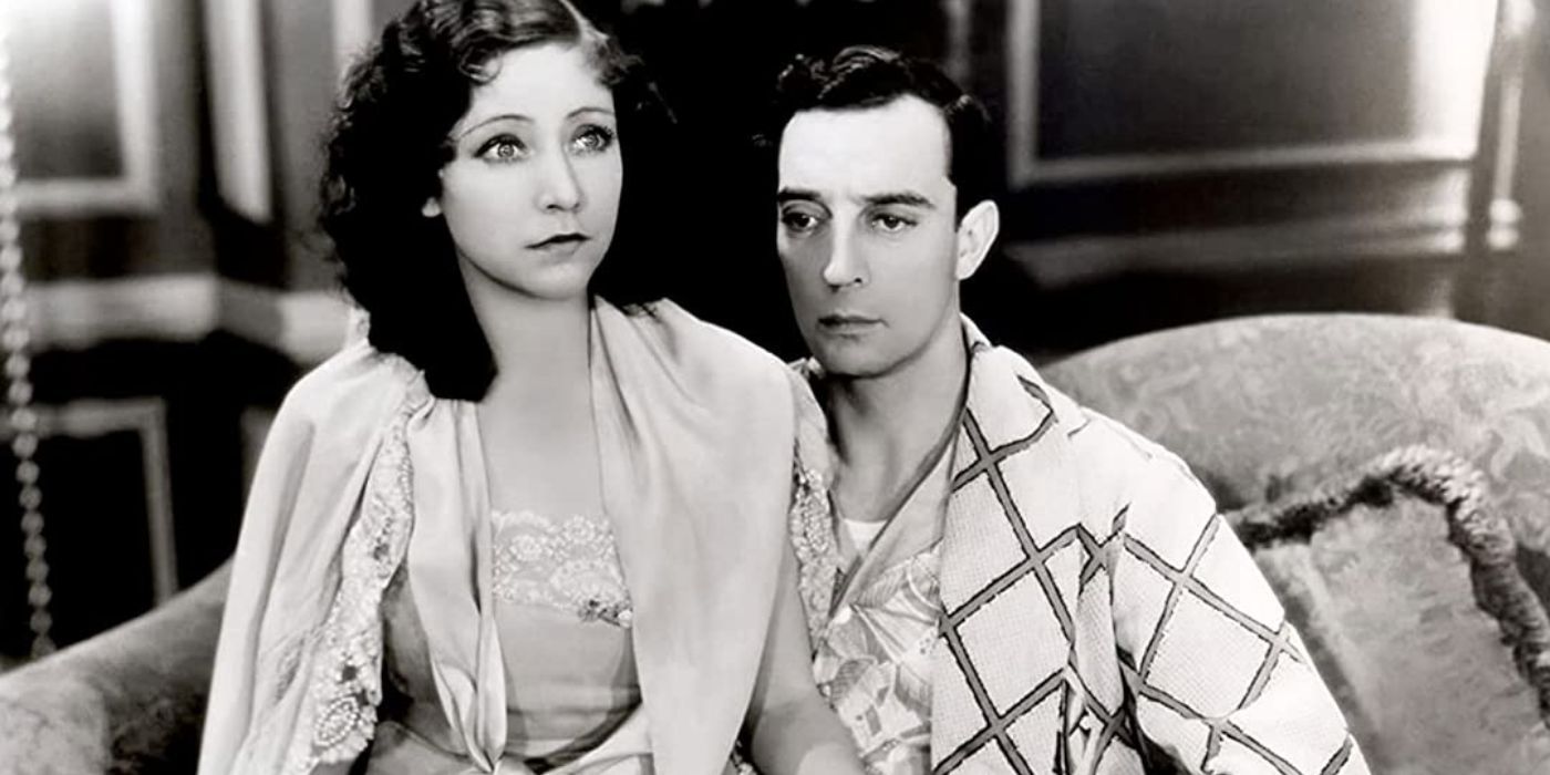 Buster Keaton sitting with a woman on a sofa in Parlor Bedroom and Bath 