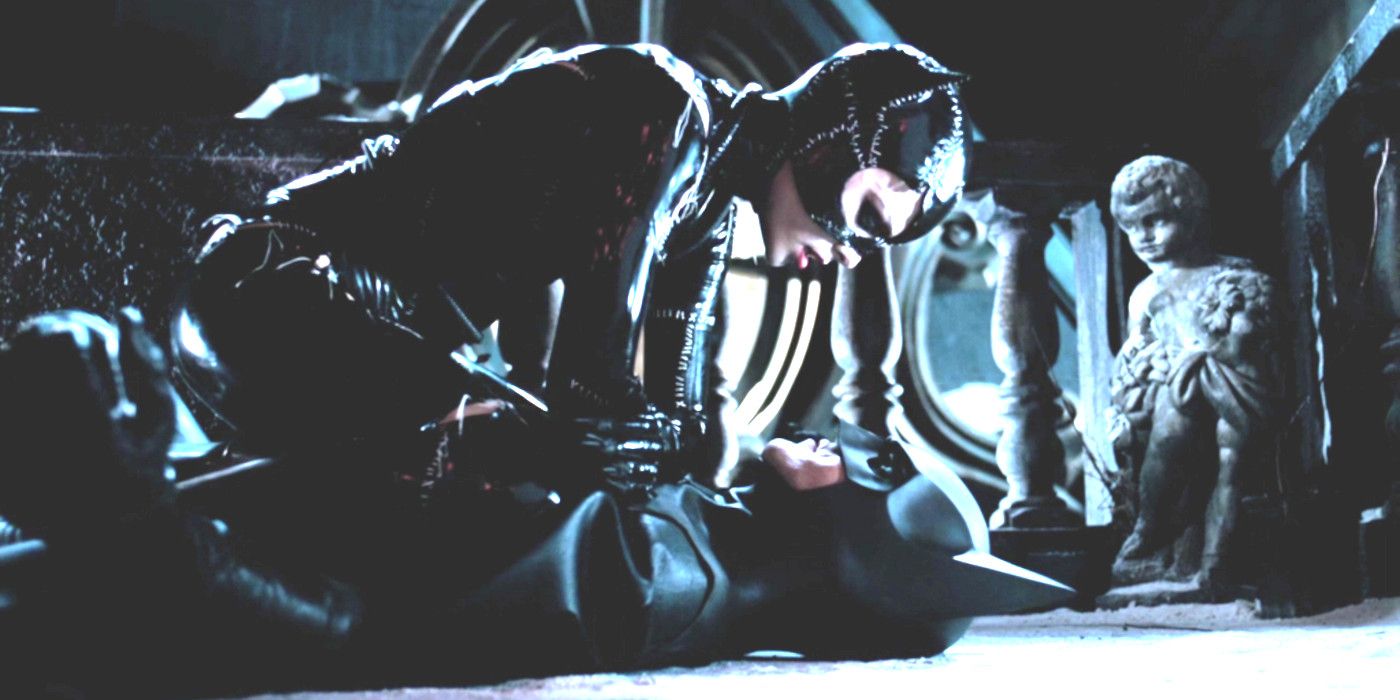 Michelle Pfeiffer as Catwoman sitting astride a prone Michael Keaton as Batman