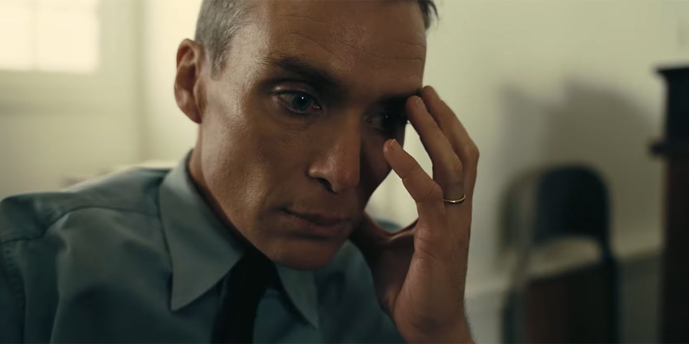 Cillian Murphy as Oppenheimer holding his hand to his head in Oppenheimer