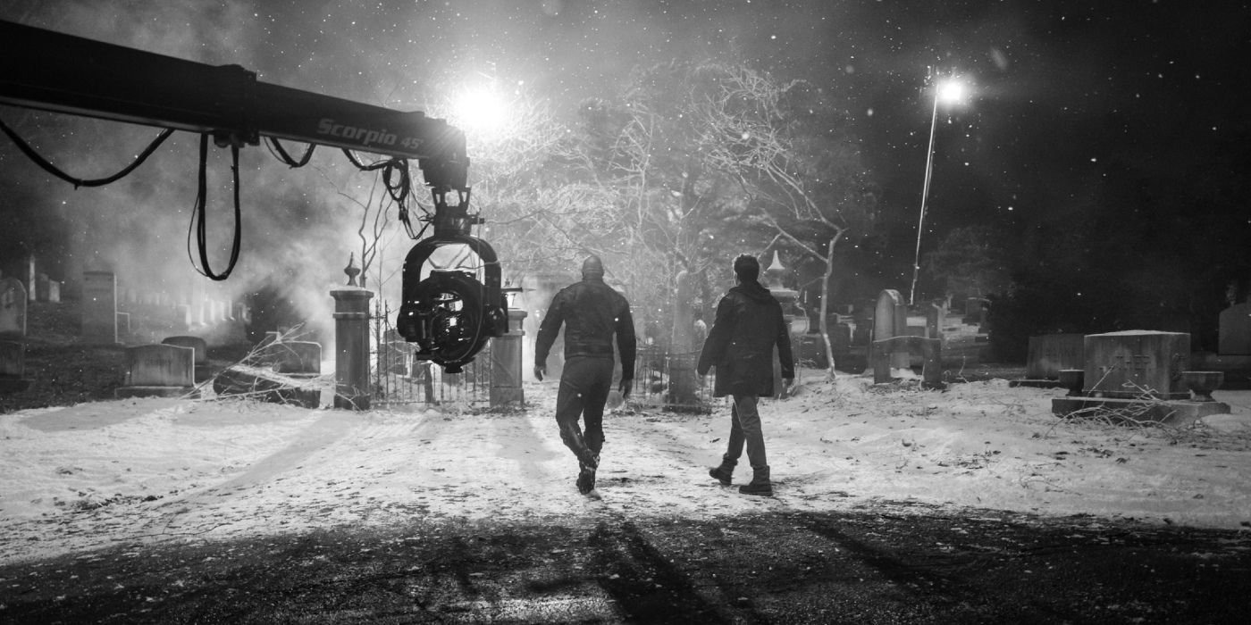 Dwayne Johnson and Chris Evans walk through a graveyard on the Red One set.