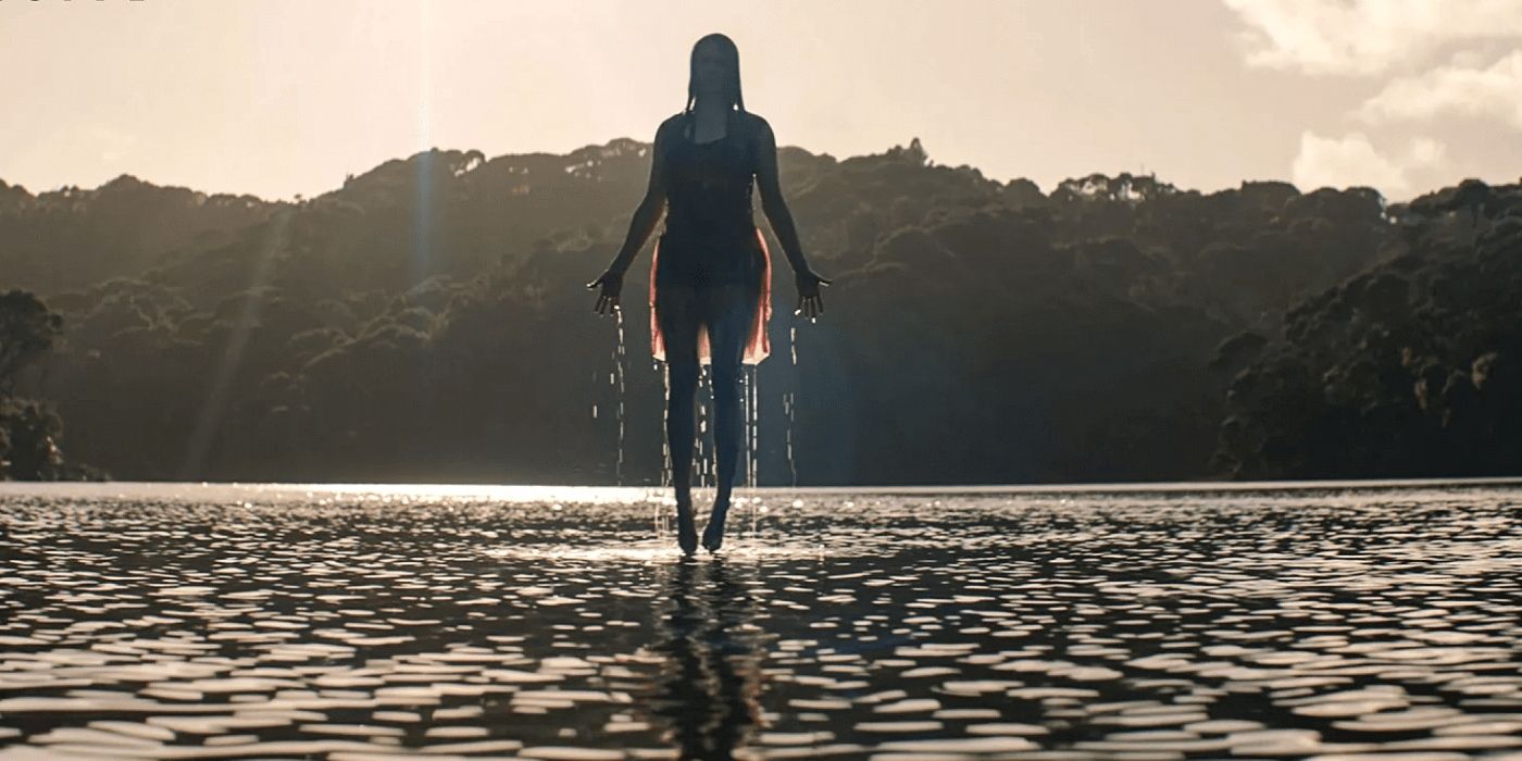 A woman ominously floats above a lake in Evil Dead Rise.