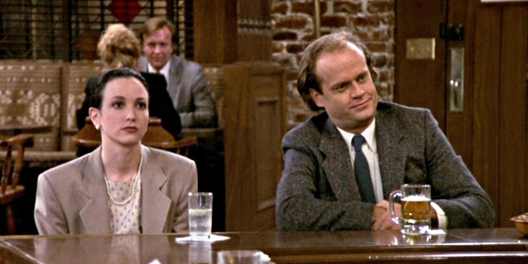 Bebe Neuwirth como Lilith e Kelsey Grammer como Frasier sentam no bar em Cheers