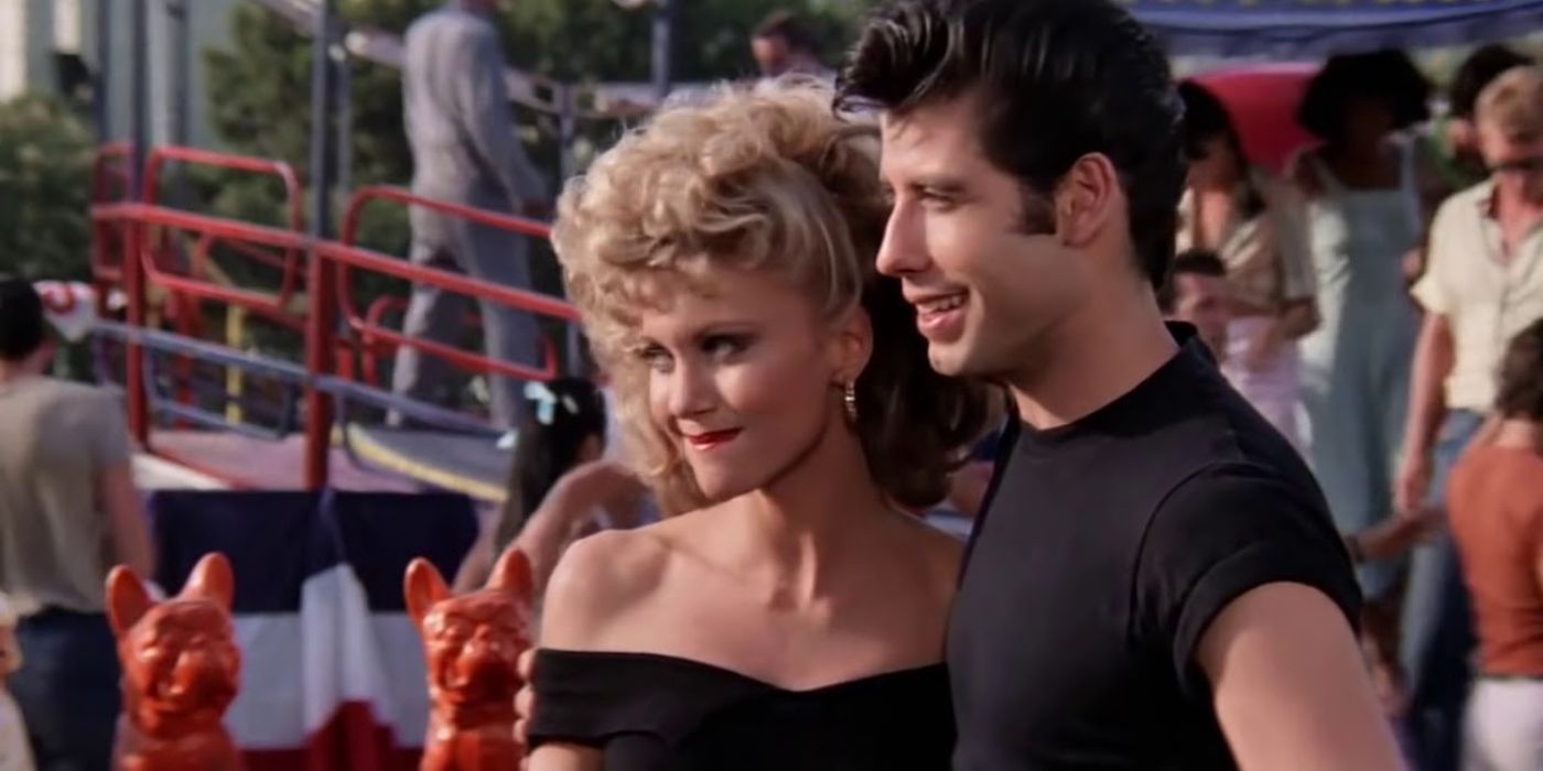 Sandy and Danny standing together smiling in Grease