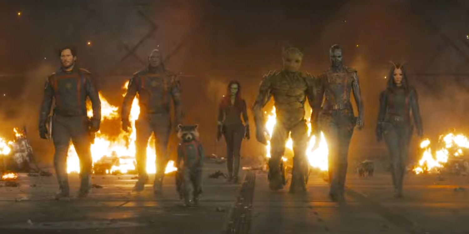 The Guardians of the Galaxy walk forward as fires burn behind them.