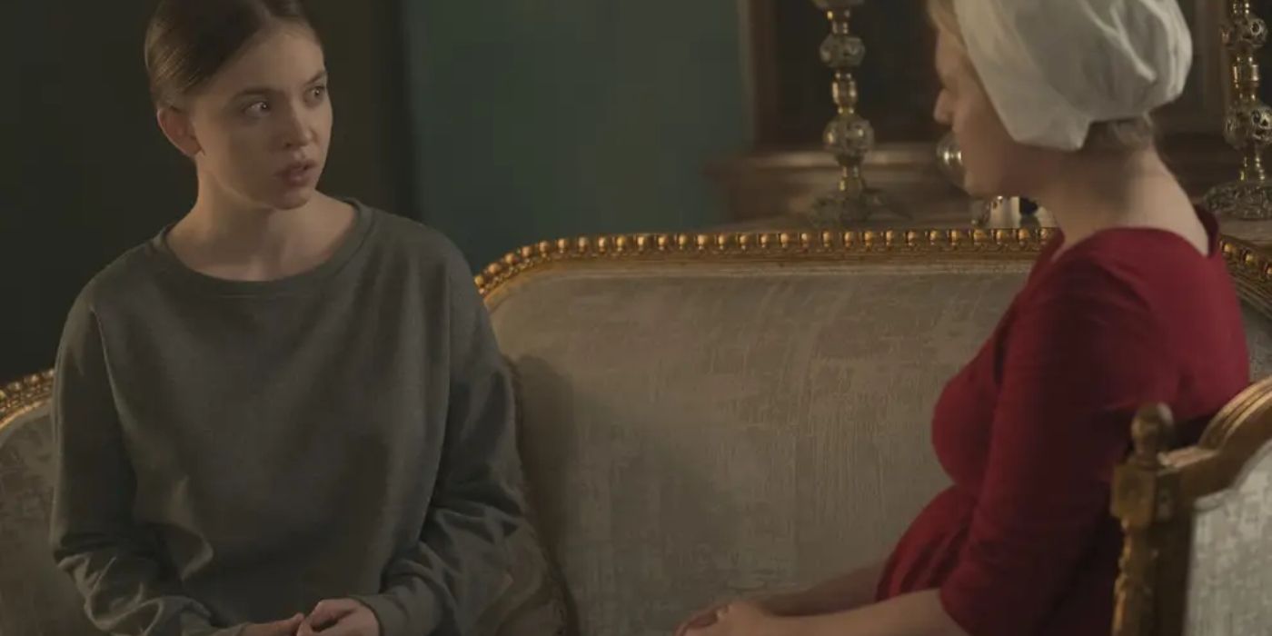 Eden and June sitting and talking on a couch in The Handmaid's Tale