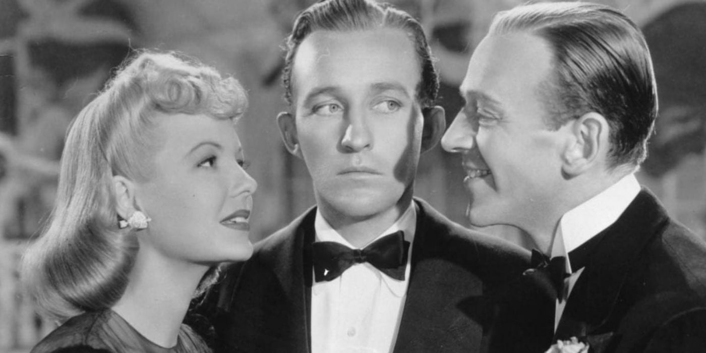 Bing Crosby como Jim Hardy parado entre Fred Astaire como Ted Hanover y Marjorie Reynolds como Linda Mason mirándose amorosamente en Holiday Inn. 