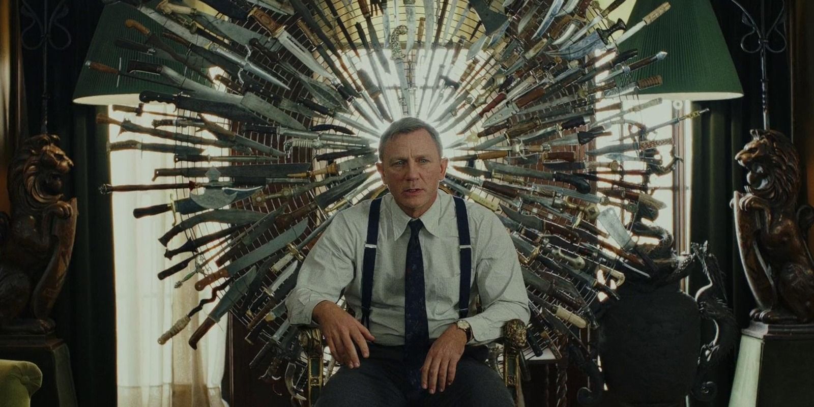 Daniel Craig sentado em uma cadeira cercado por facas em Knives Out.