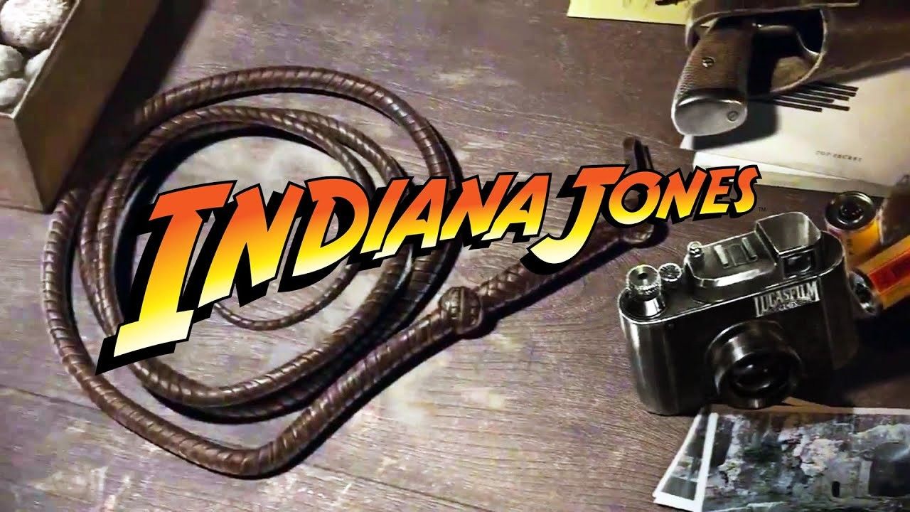 Chicote de Indiana Jones e uma câmera da Lucasfilm em uma mesa com a fonte do logotipo de Indiana Jones no topo.