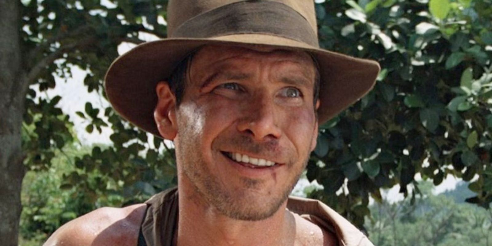 Indiana Jones smiling in the woods.