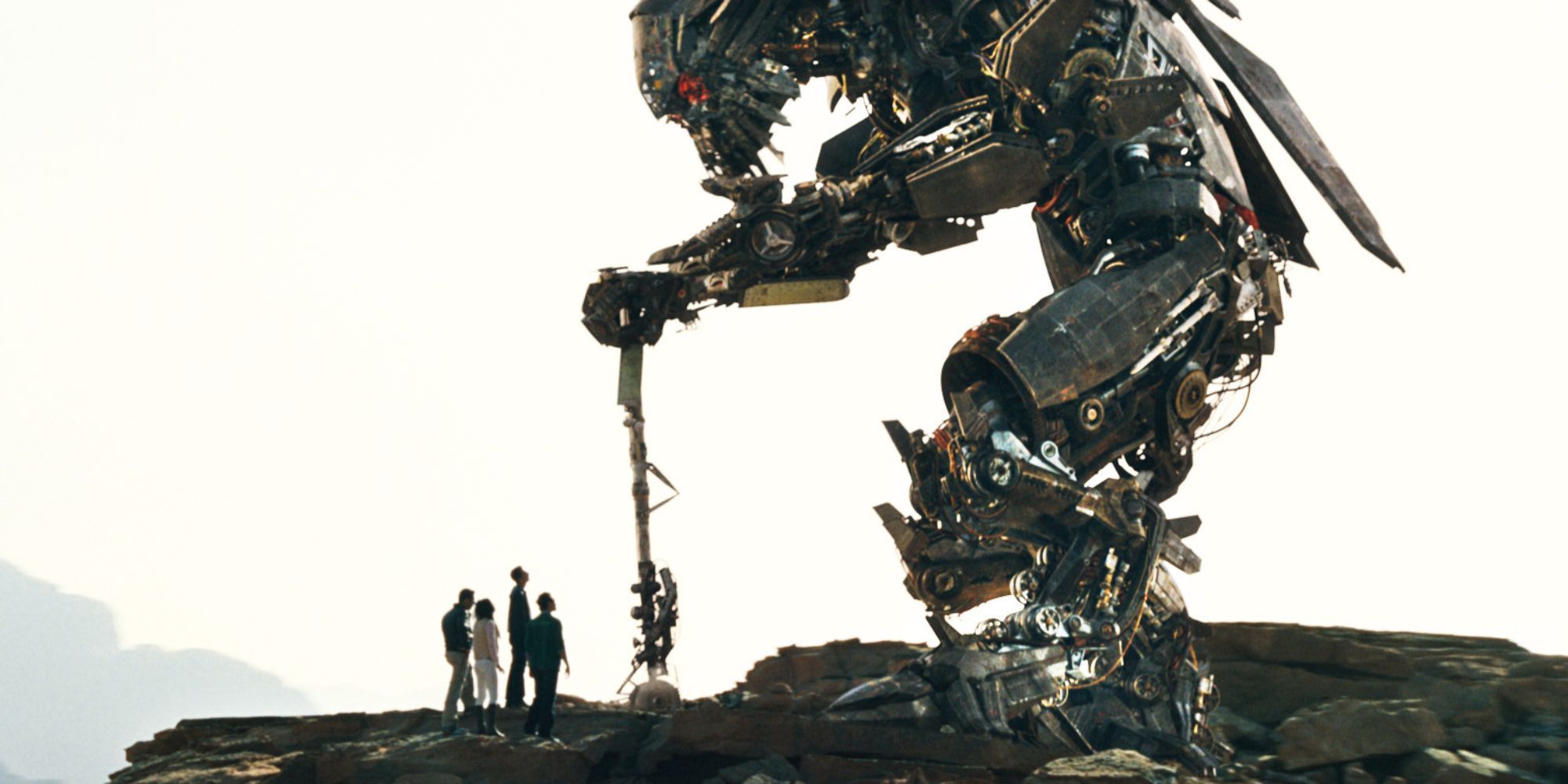 jetfire em pé sobre humanos em um penhasco em Transformers Revenge of the Fallen 