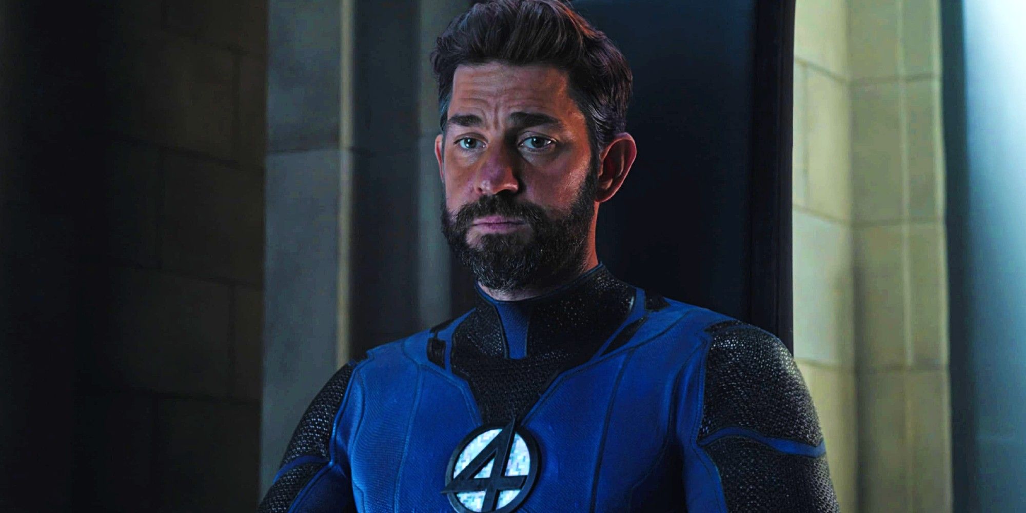 John Krasinski como Reed Richards/Senhor Fantástico sentado e olhando para Estranho em Doutor Estranho no Multiverso da Loucura 