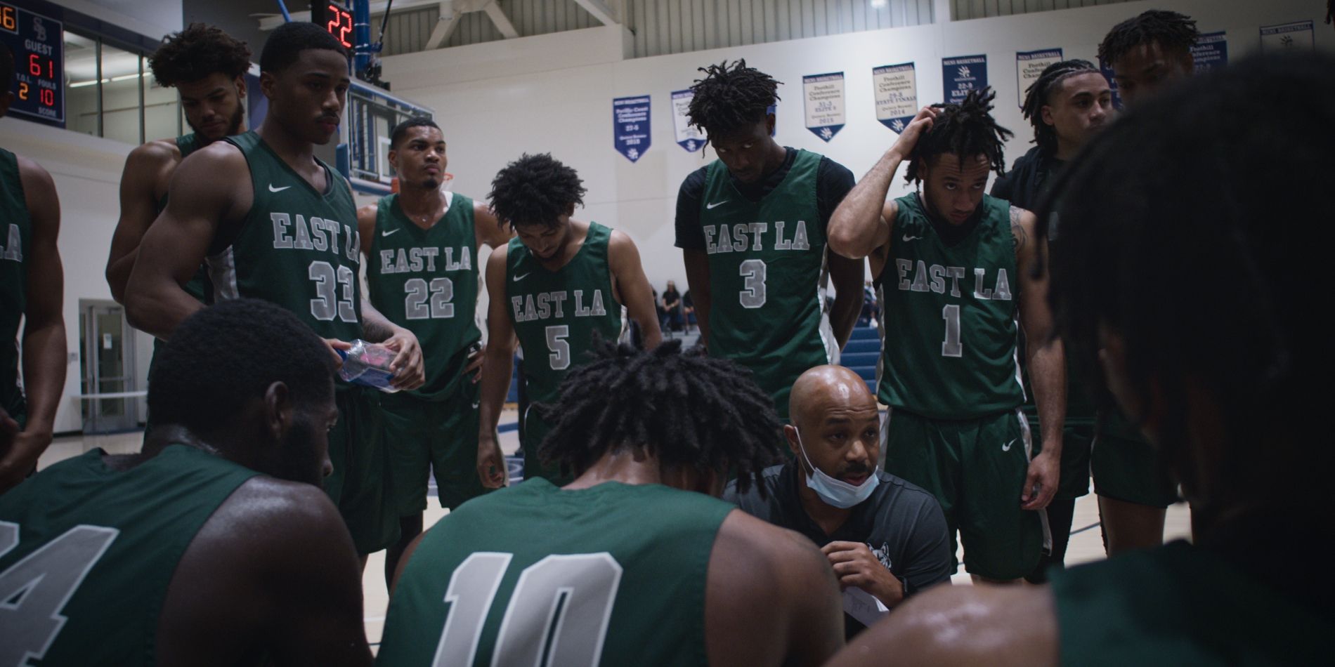 Coach Mosley huddles up with the players in Last Chance U: Basketball Season 2.