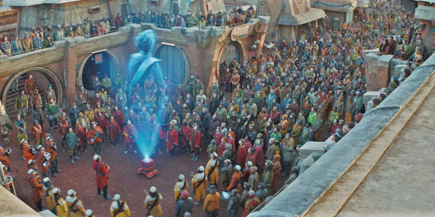 Os cidadãos de Ferrix assistem ao holograma de Maarva (Fiona Shaw) em Andor.
