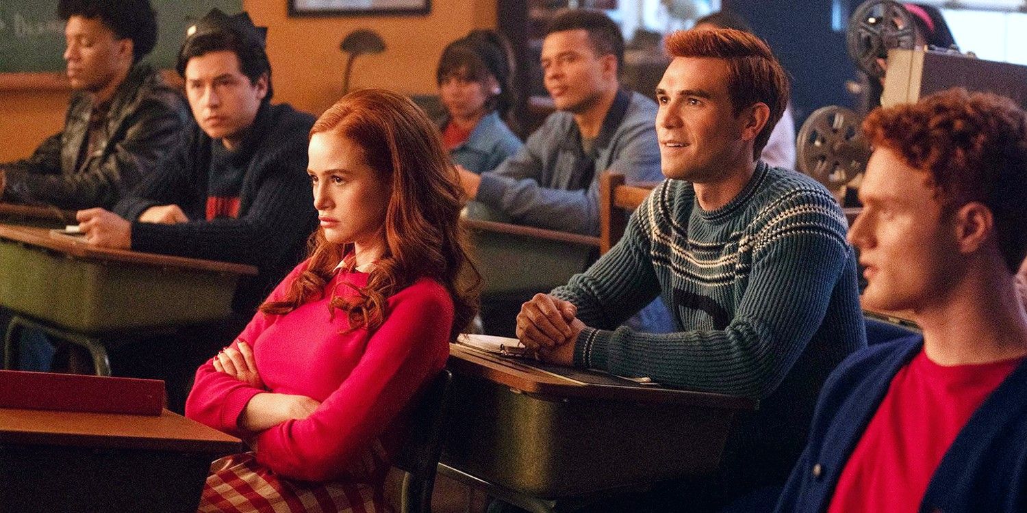 Madelaine Petsch as Cheryl Blossom and KJ Apa as Archie Andrews sitting in class in Riverdale season 7