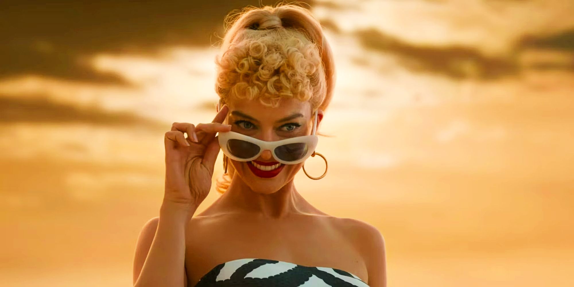 Margot Robbie smiling and tilting sunglasses down in Barbie movie