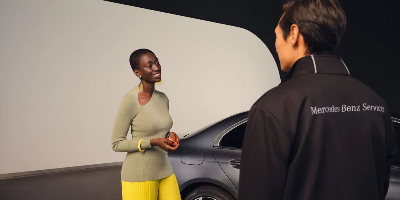 Photo of a smiling lady with a Mercedes Service technician