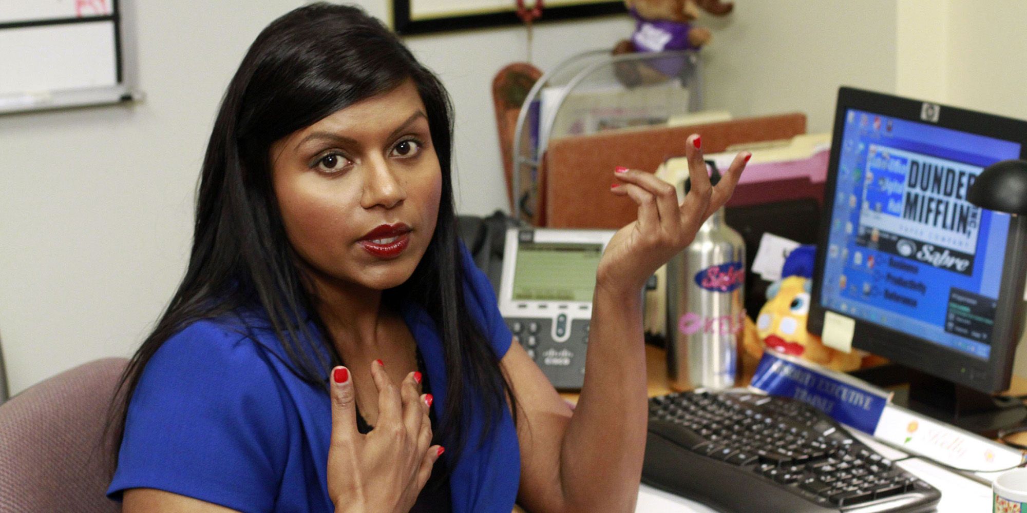 Kelly Kapoor seated in front of a computer in The Office