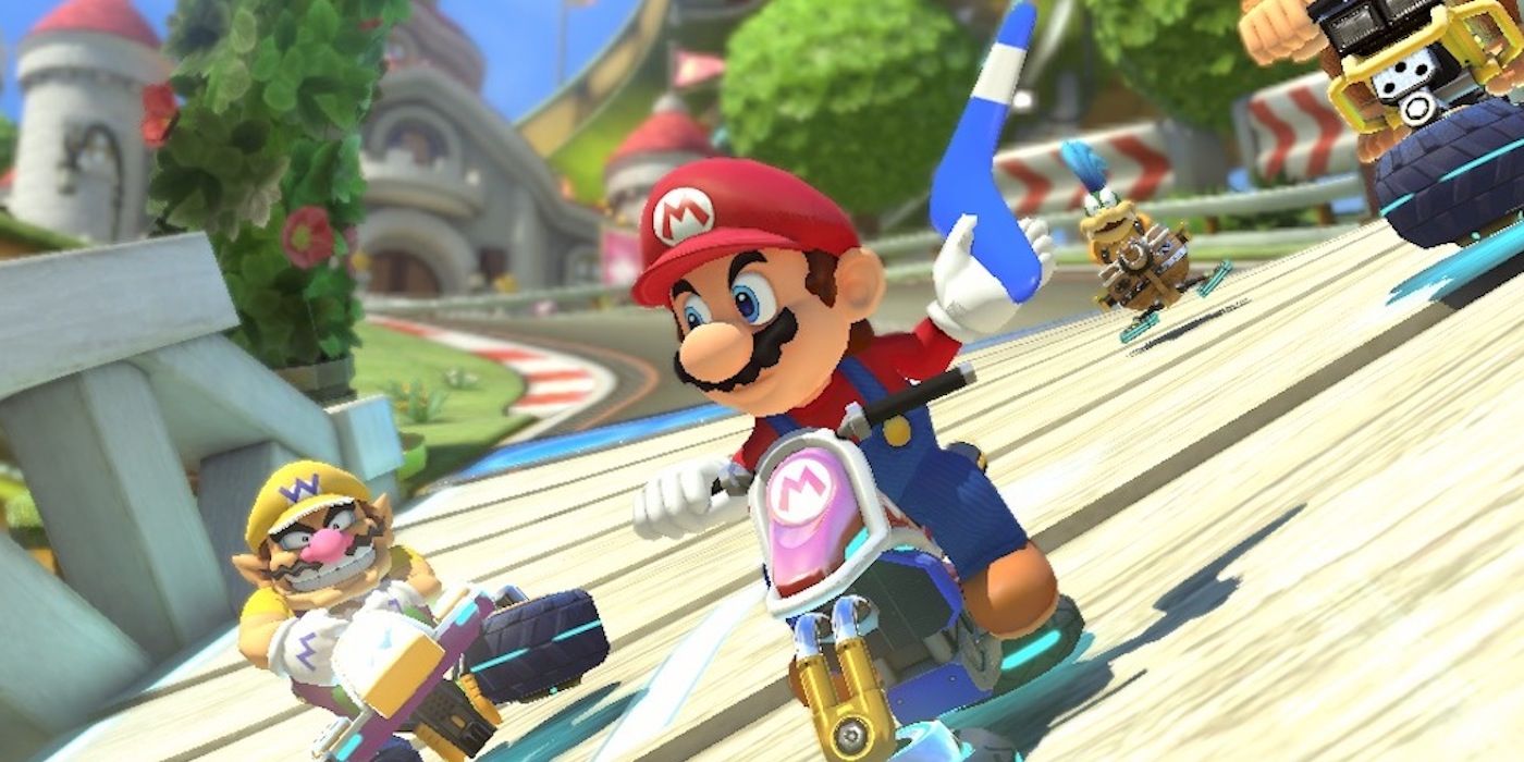 Mario holding a boomerang in Mario Kart 8 while Wario races behind him