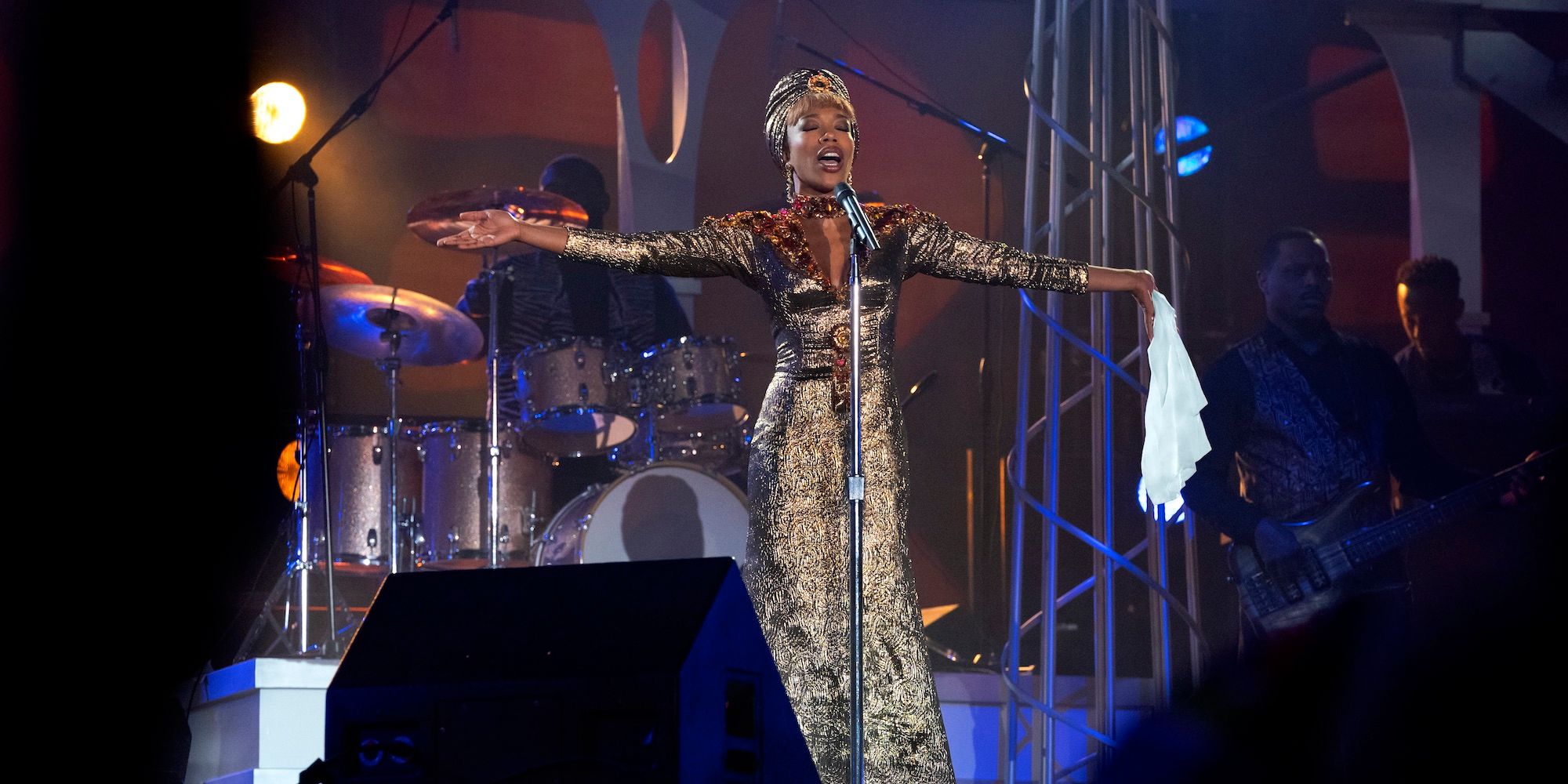 Naomi Ackie en el escenario vestida de oro y Whitney Houston en 