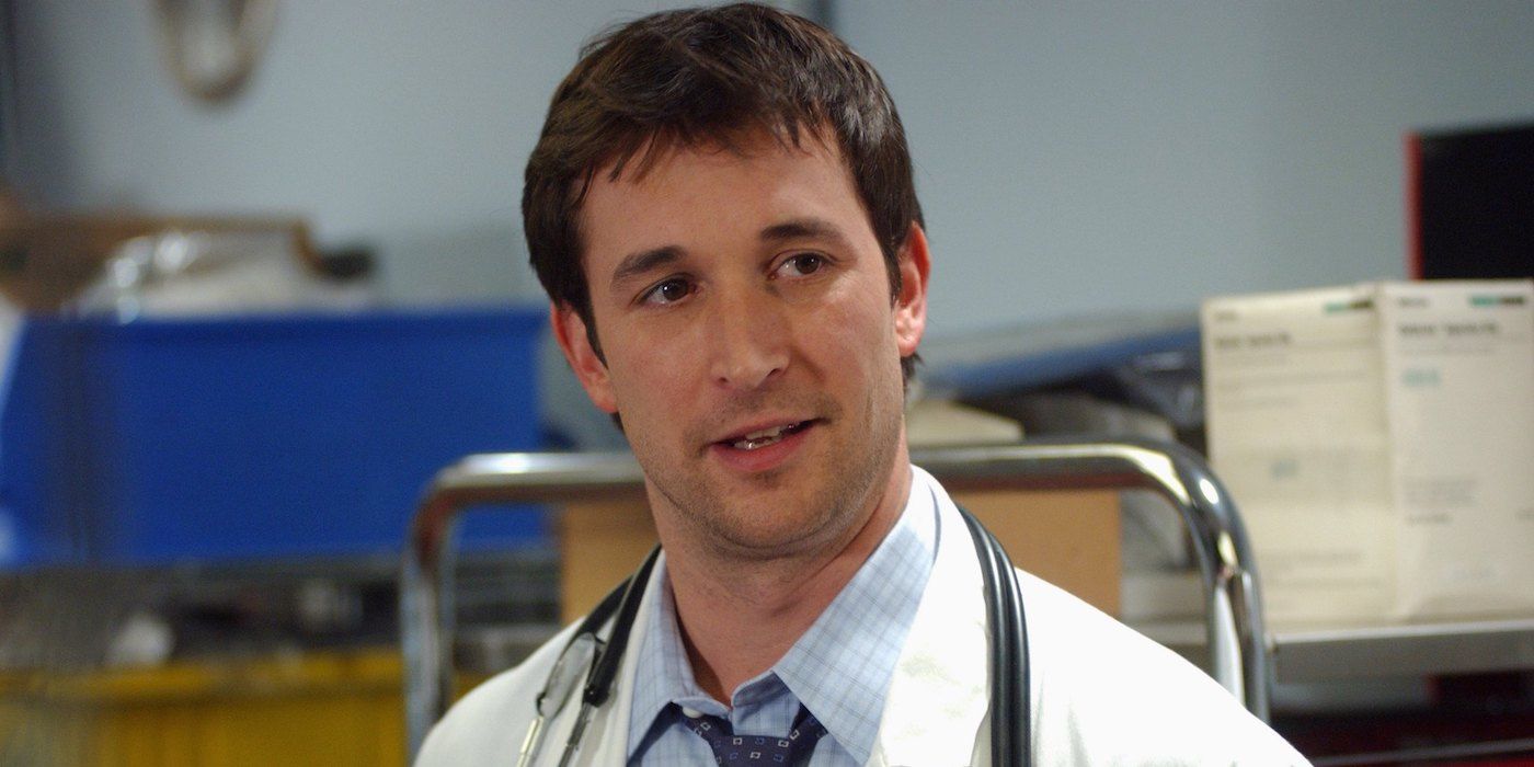 急诊室里的诺亚·怀尔 (Noah Wyle) 穿着医用手术服，目光移向别处