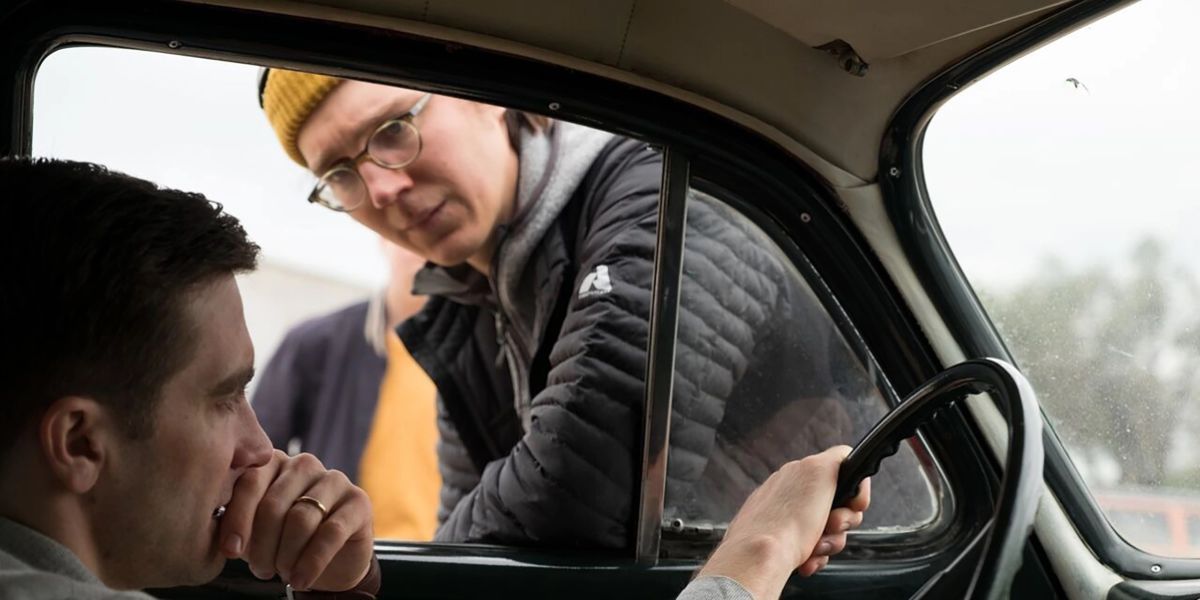 paul dano olhando para dentro de um carro em jake gyllenhaal enquanto dirige a vida selvagem