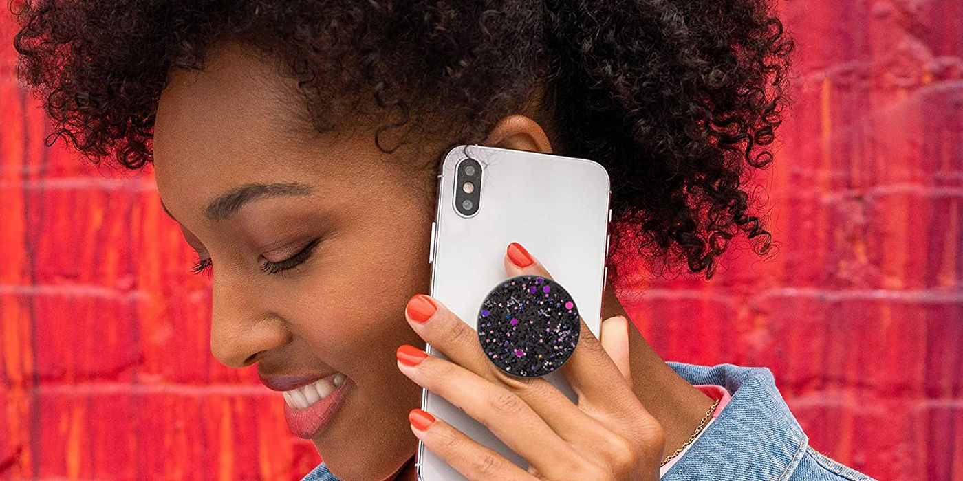 woman with phone to her ear, a popsockets sparkle on its back