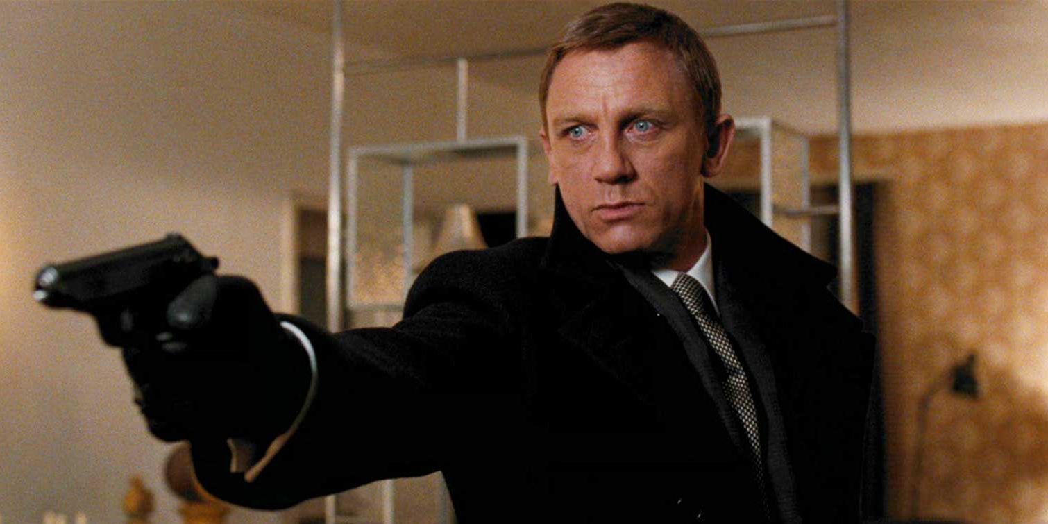 Daniel Craig as James Bond wearing a coat and holding up a gun in Quantum of Solace