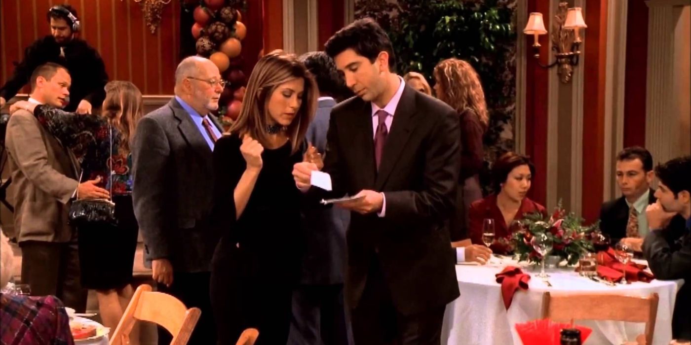 Rachel e Ross abrindo um cheque de presente no aniversário de casamento de Geller em Friends.