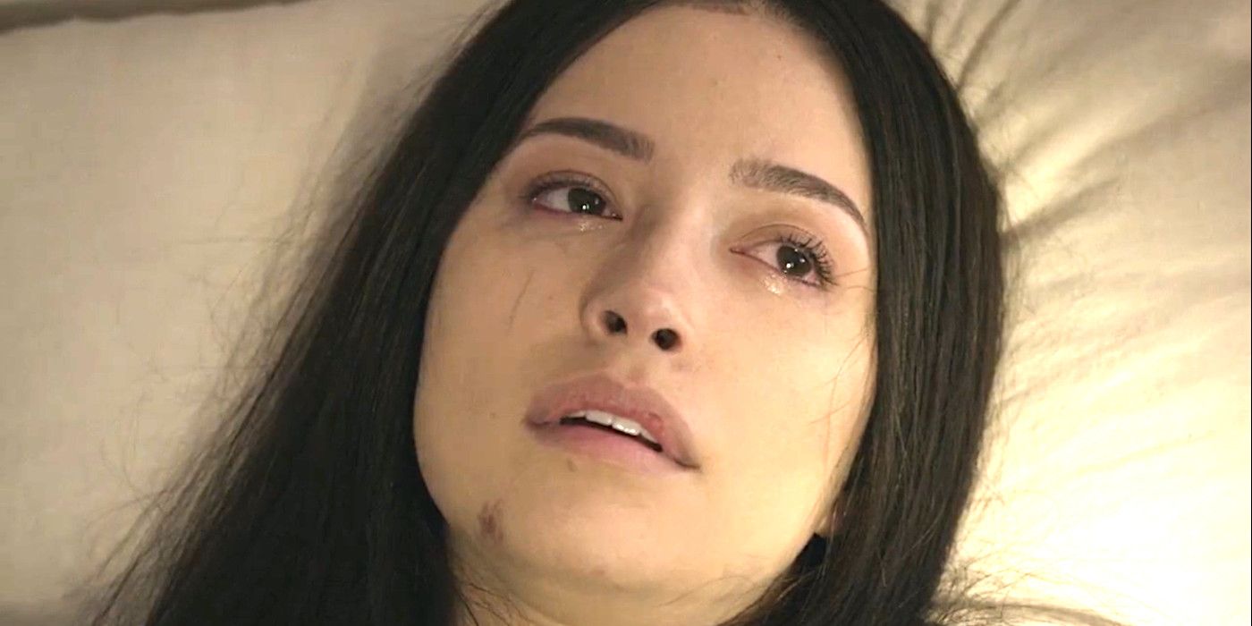 Christian Serratos as Rosita in The Walking Dead series finale lying in bed looking pale and resigned, on the verge of death
