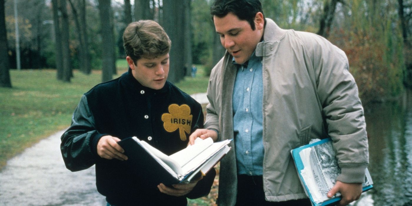 Rudy and D-Bob looking at a textbook outside campus in Rudy