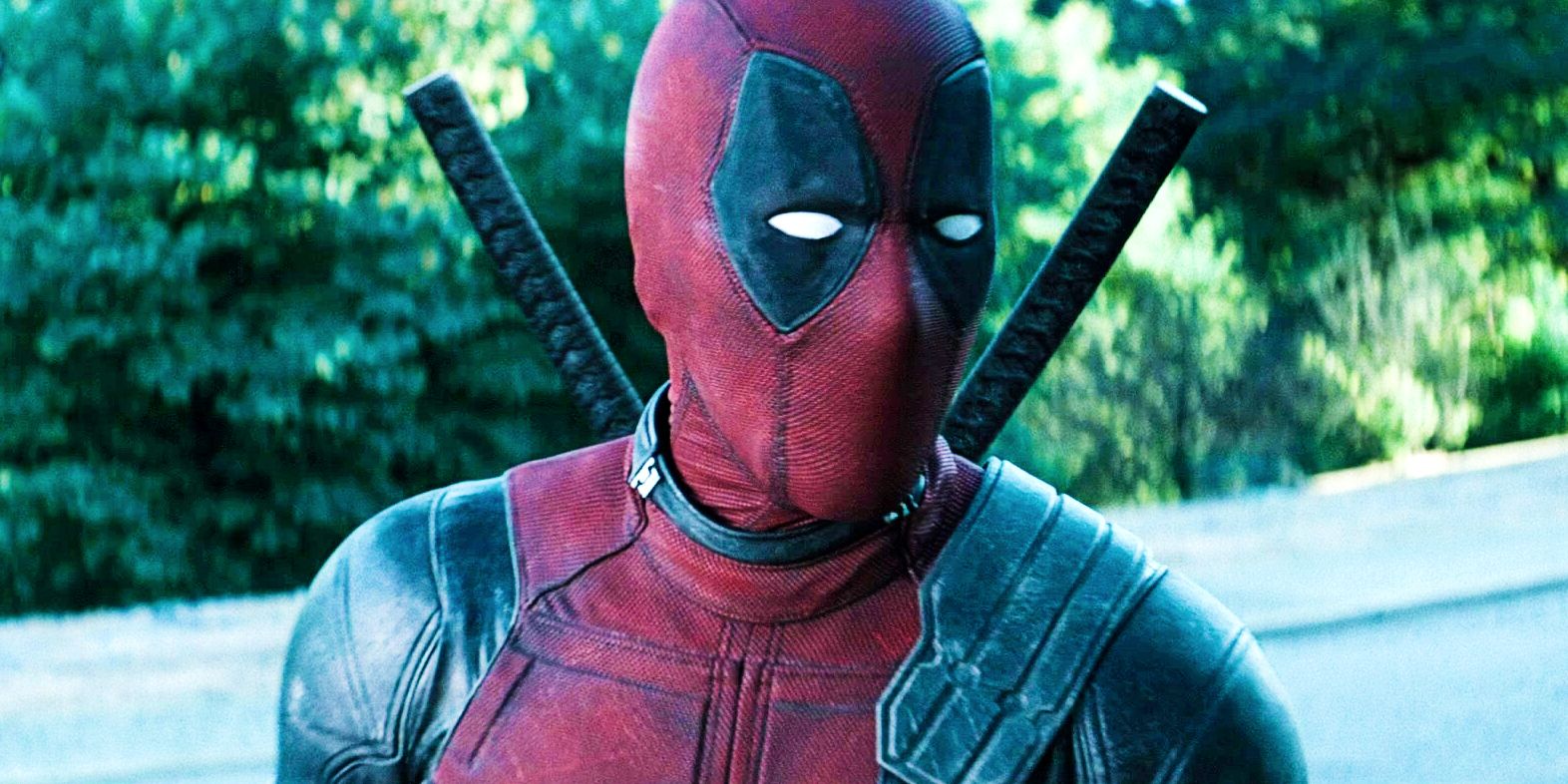 Ryan Reynolds as Deadpool in Deadpool 2 standing in front of trees