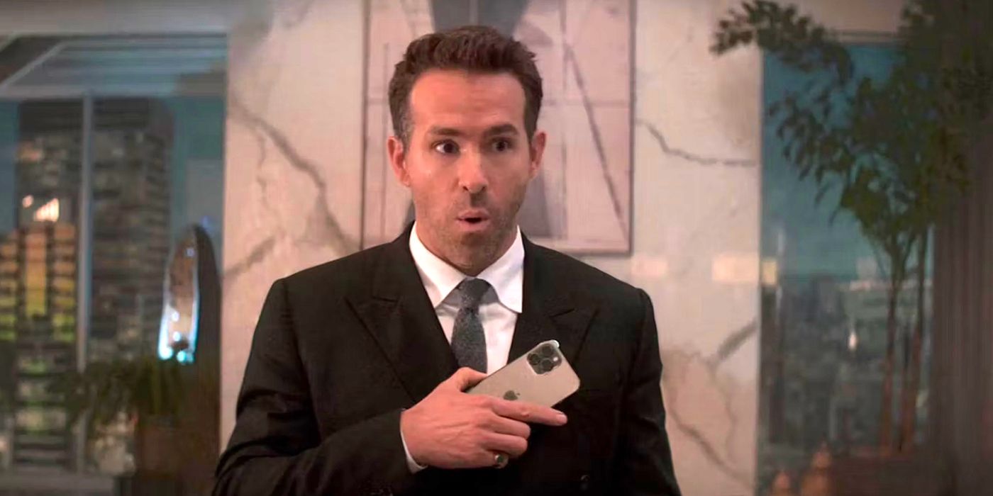 Ryan Reynolds holding a phone and looking surprsied in Spirited