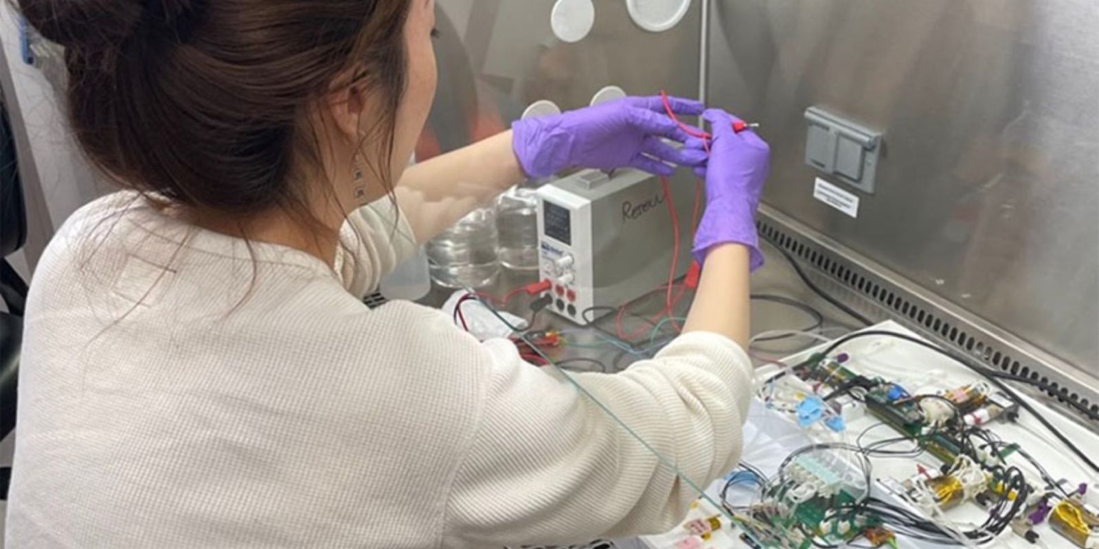 Cientista trabalhando com uma máquina que transforma plástico em material utilizável no espaço.