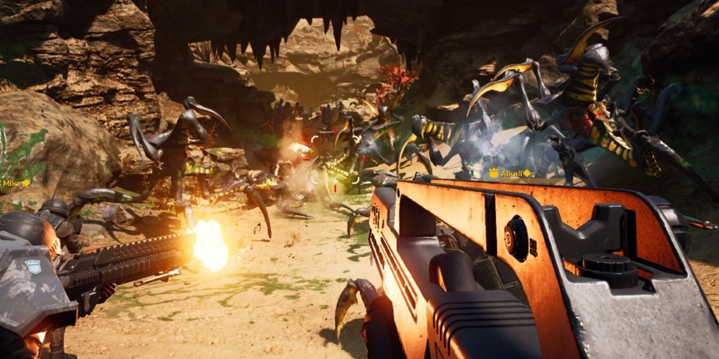 Screenshot of Starship Troopers: Extermination. First-person image of soldiers fighting bugs on a desert planet.