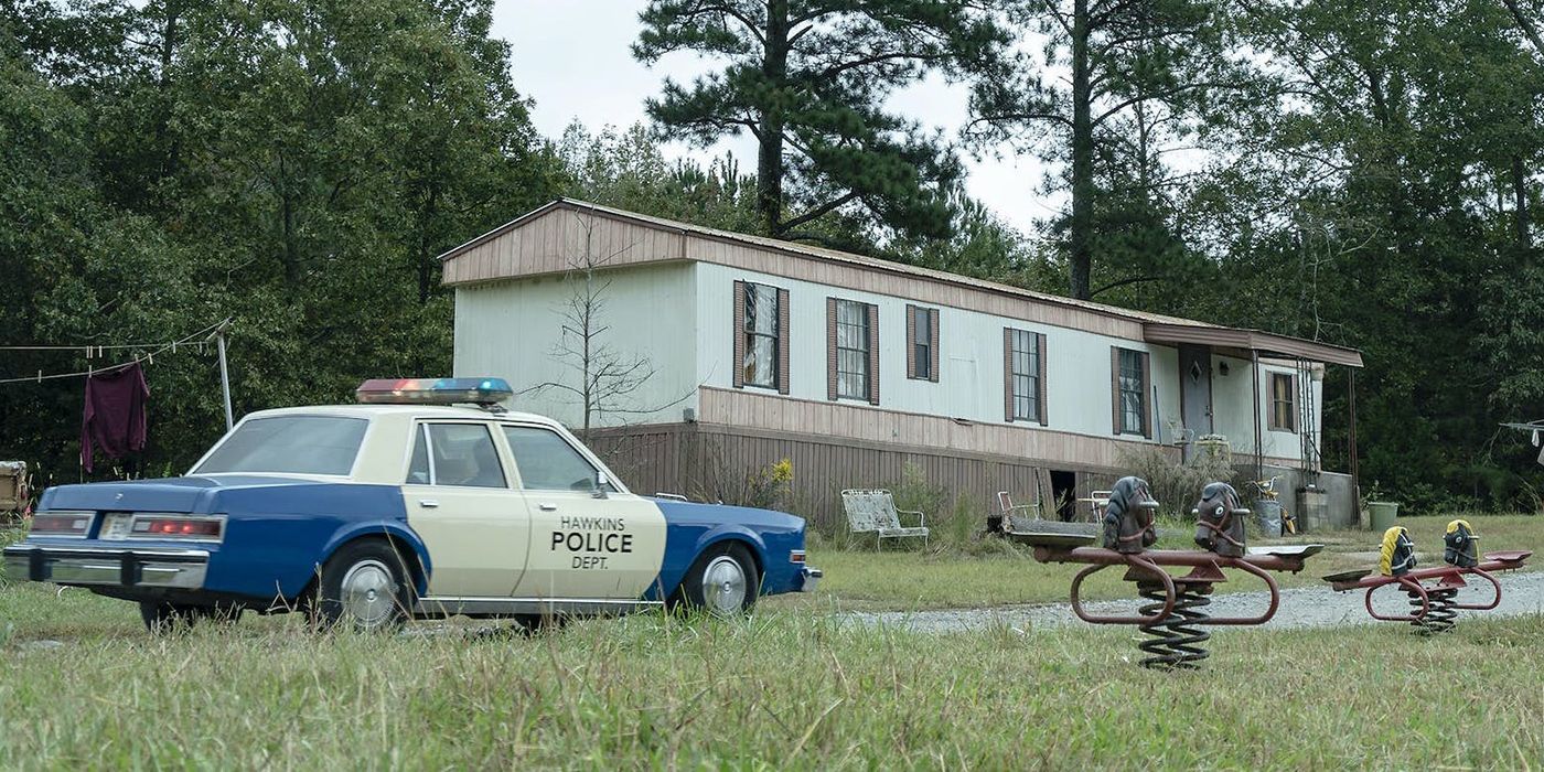 An image of Max's trailer with a police car in the foreground on Stranger Things.