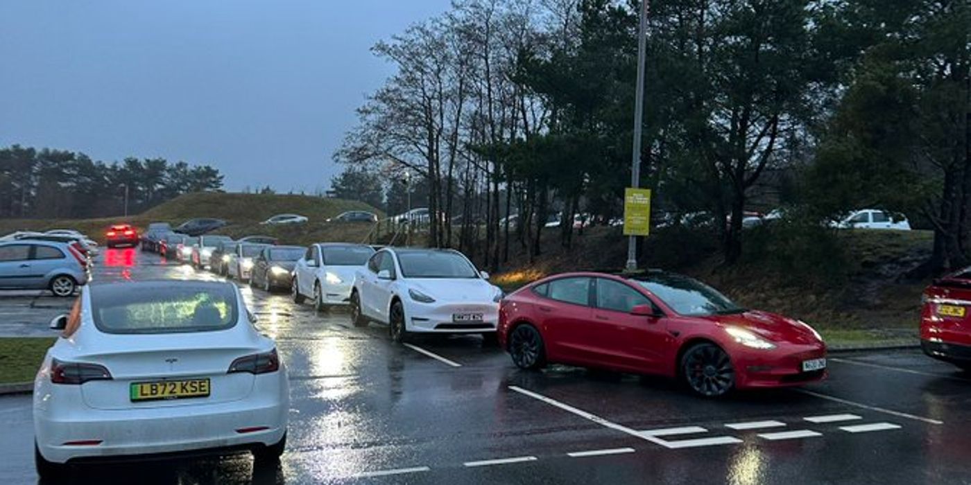 Tesla EVs waiting in line to charge in the UK