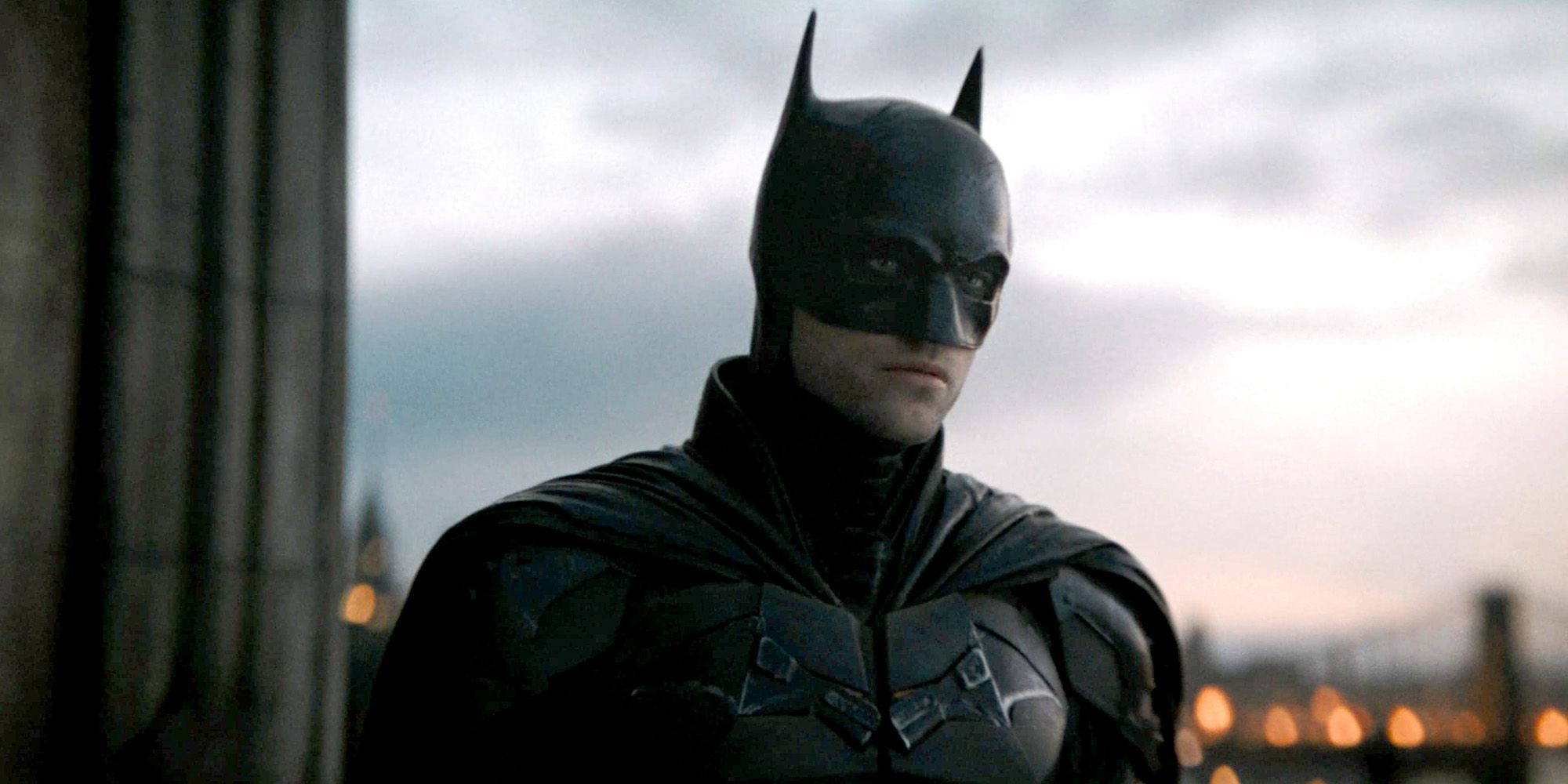 Robert Pattinson como Batman parado em um telhado