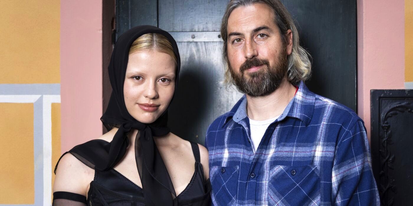 Mia Goth and Ti West smiling straight at the camera in a promotional image for Pearl