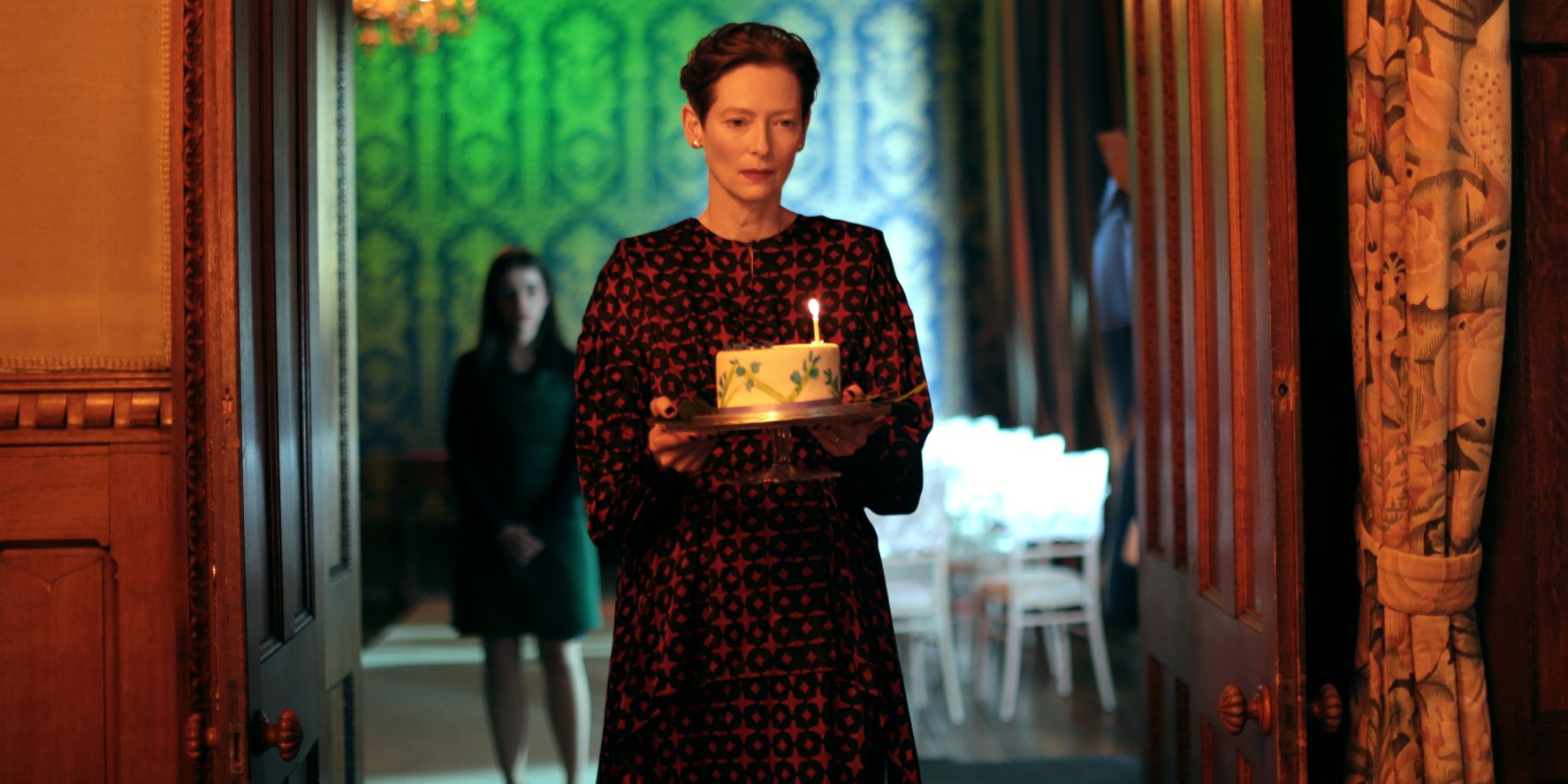 Tilda Swinton as Julie holding a birthday cake in The Eternal Daughter
