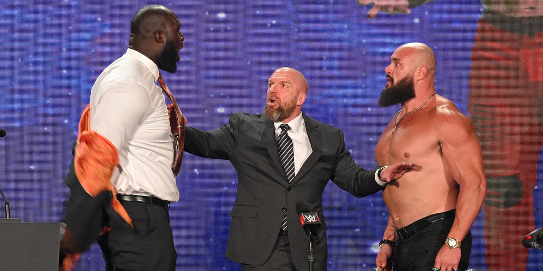 Triple H stands between Omos and Braun Strowman during a press conference ahead of WWE Crown Jewel in 2022.