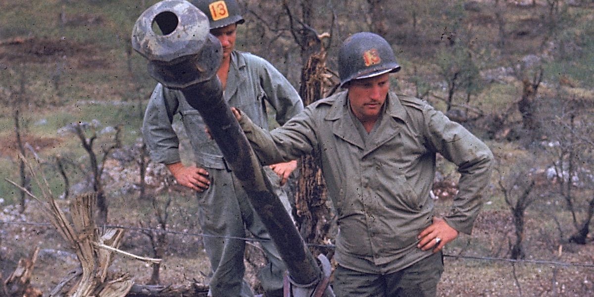 Dois homens ao lado de uma grande arma na Segunda Guerra Mundial em HD