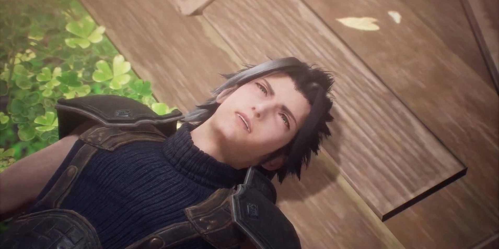 Zack Fair after he fell into Aerith's church in Crisis Core: Final Fantasy 7 Reunion, laying on a field of clovers, with his head on a wooden floor.