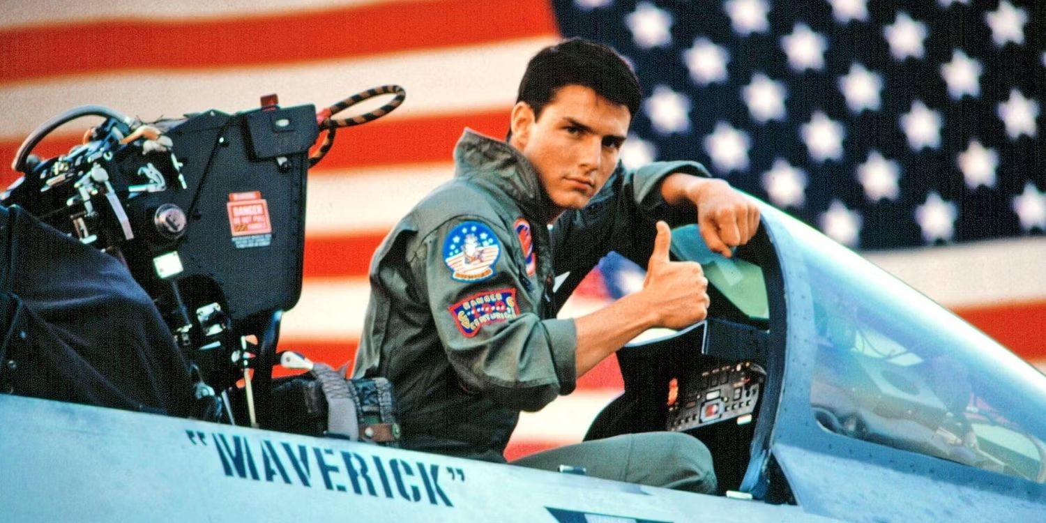 Tom Cruise sitting in a cockpit and giving a thumbs up in Top Gun