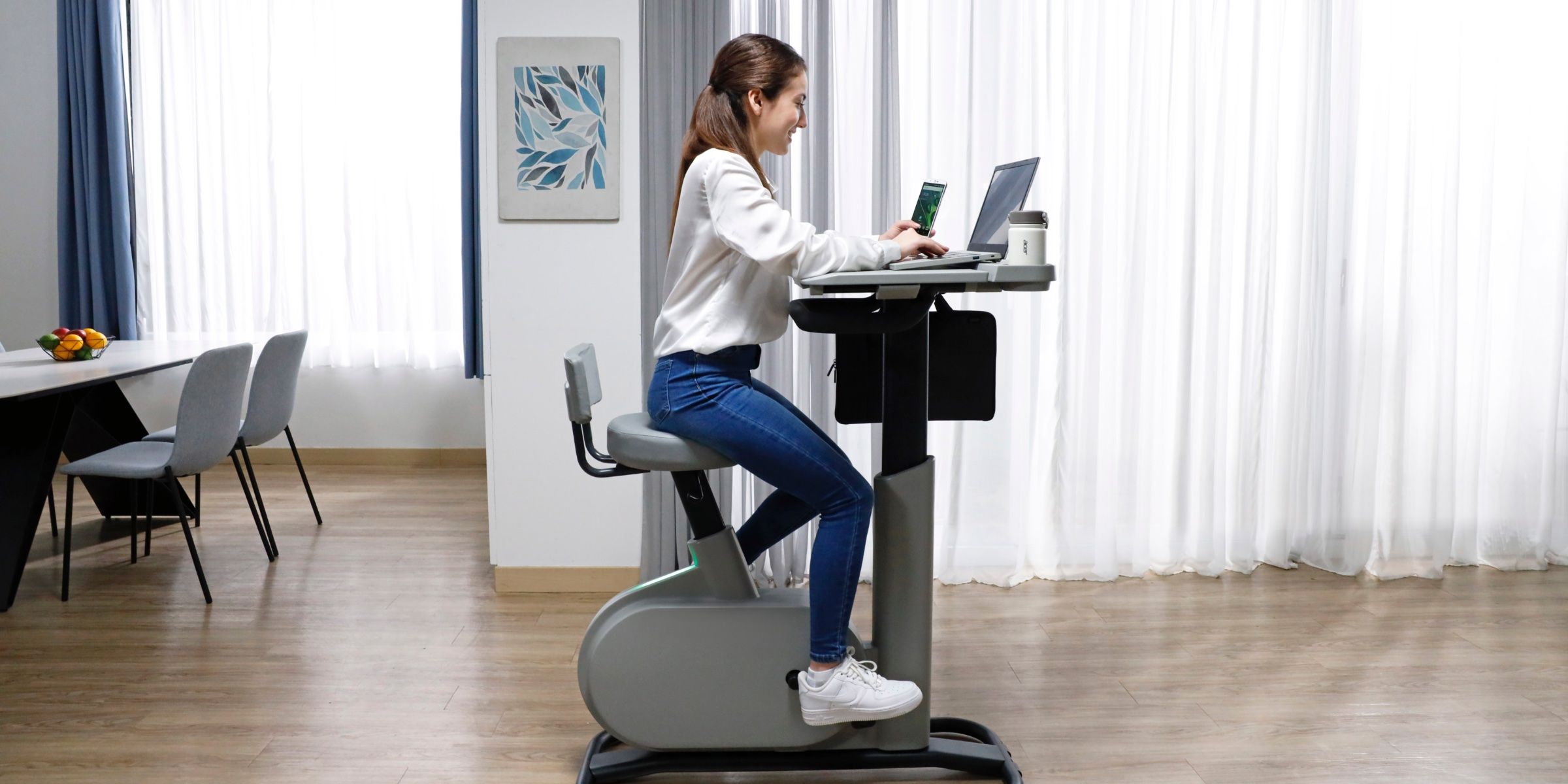 A woman riding the eKinect BD 3 Acer Desk Bike.