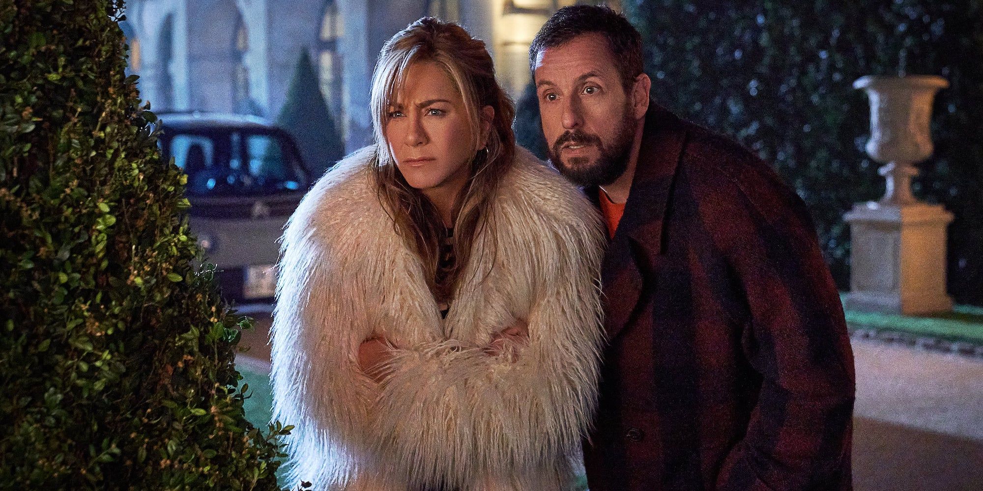 Adam Sandler looking concerned and Jennifer Aniston wearing a fur coat in Murder Mystery 2