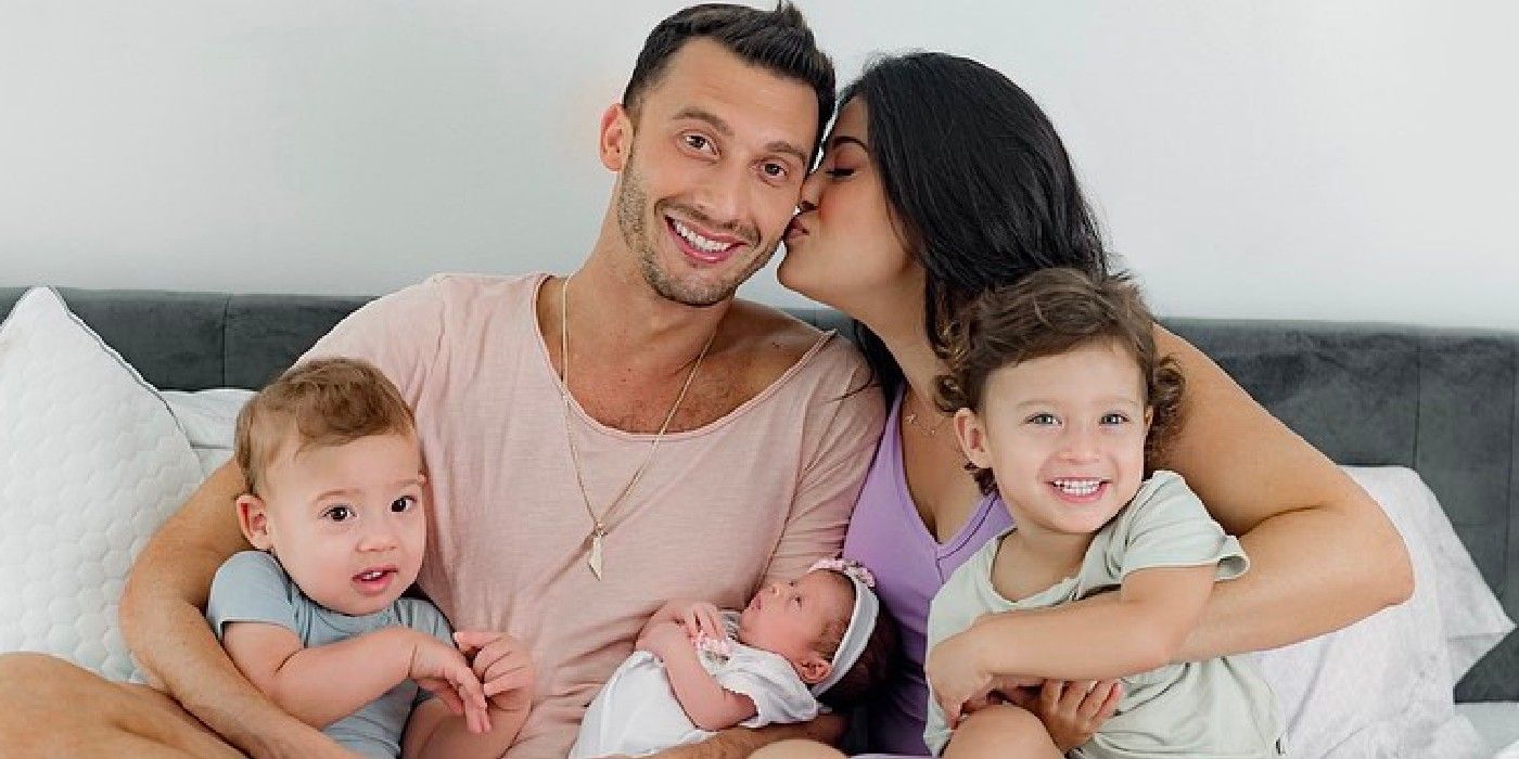 90 Day Fiancé stars Loren kissing her husband Alexei Brovarnik with their kids on a bed